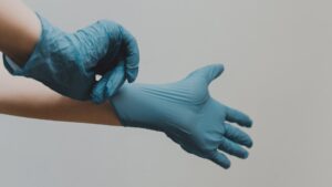 A person is donning blue latex gloves.