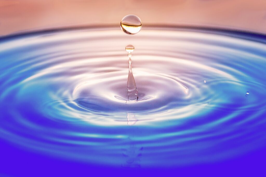 A drop of water bouncing over water.