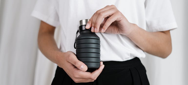 A person holding a reusable water bottle
