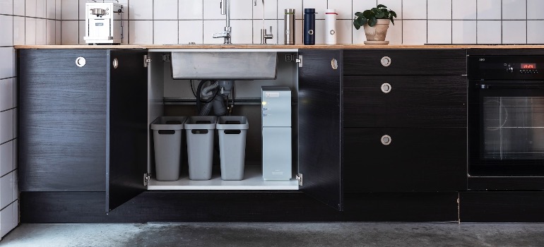 A water purification system under a sink in a kitchen.